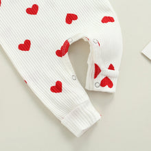 Heart print baby romper worn by a baby girl
