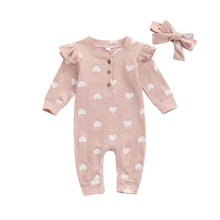 Heart print baby romper worn by a baby girl