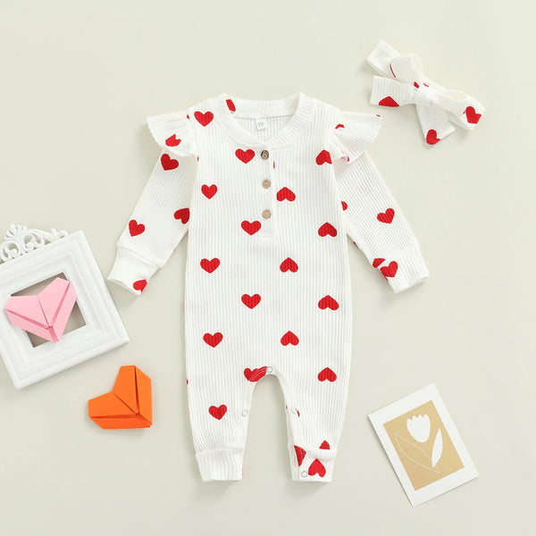 Heart print baby romper worn by a baby girl