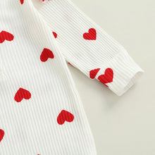 Heart print baby romper worn by a baby girl