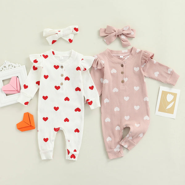 Heart print baby romper worn by a baby girl