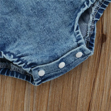 Baby denim romper worn by a baby girl