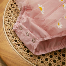 Daisy print baby romper worn by a baby girl