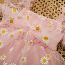 Daisy print baby romper worn by a baby girl