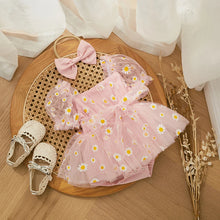 Daisy print baby romper worn by a baby girl