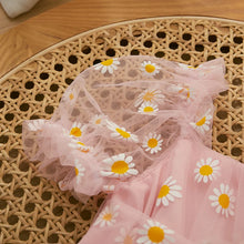 Daisy print baby romper worn by a baby girl