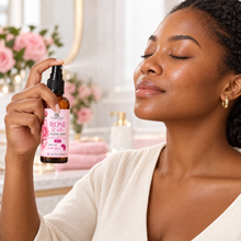 W Cosmetics rose facial mist 50ml amber spray bottle with a pink floral label beside pink roses